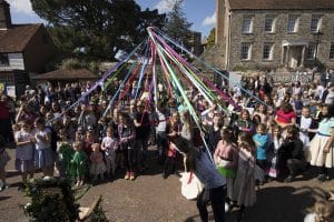 Photo of a crowd joining in to dance round the Maypole at the Mayfield Mayfair